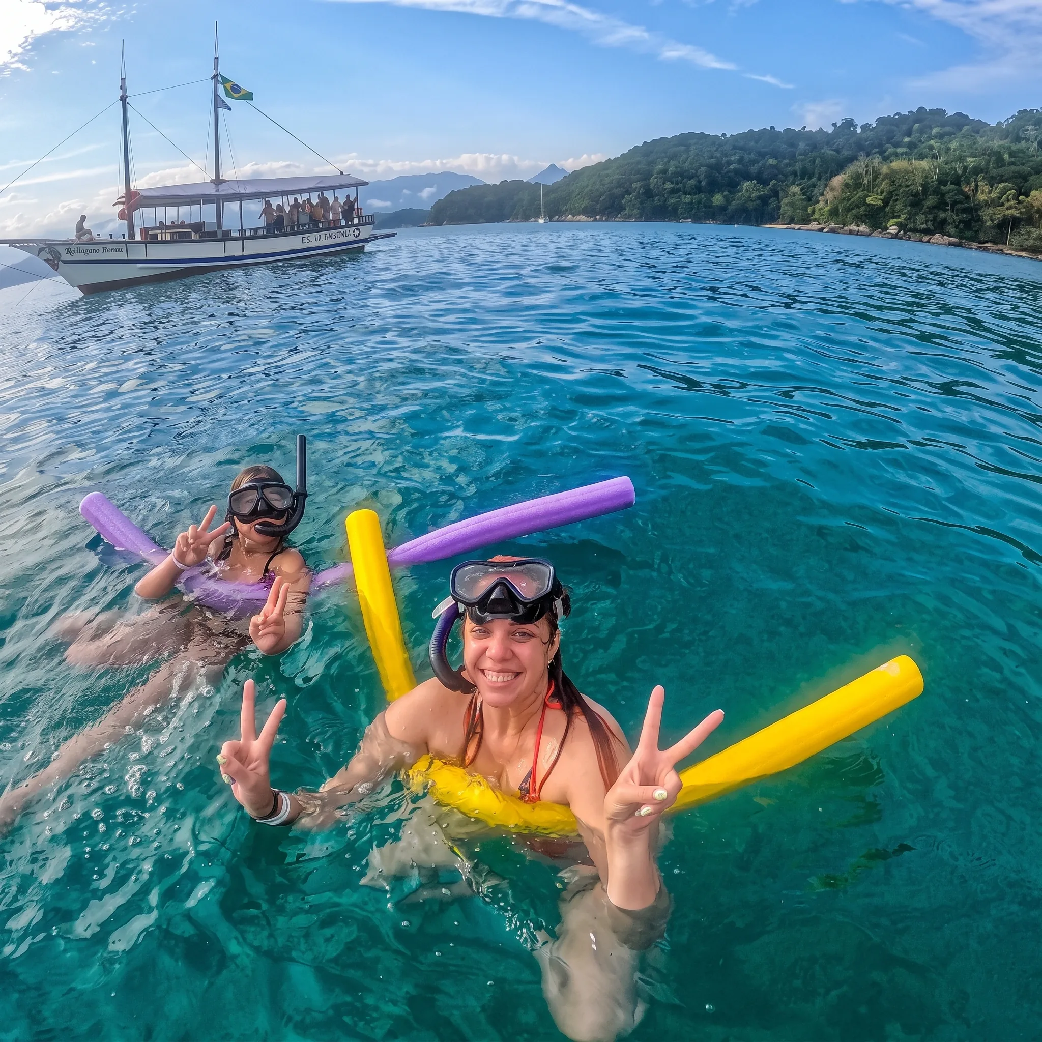 Passeio de barco em Paraty com mar e montanhas ao fundo
